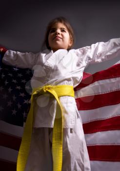 Girl karate yellow belt with US flag winner of competition