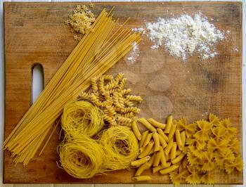 background from dry pasta items lying on the kitchen table top view