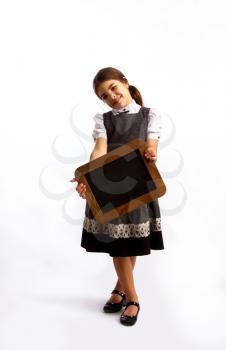 little girl in a simple modest dress smiling holds a rough dark empty chalk board
