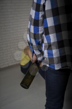 a drunk man in a worn checkered shirt with a bottle of alcohol came home to his distressed wife