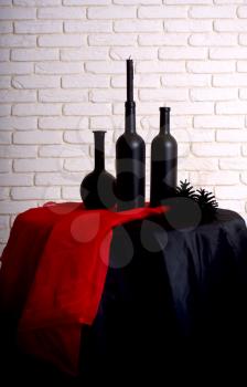 black wine bottles on black and red drapery