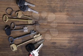 several keys of different years and shapes on an old wooden background