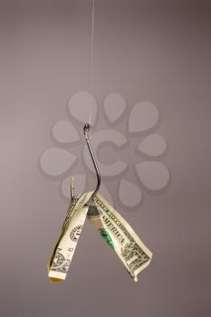 Conceptual image of a fish hook with a dollar banknote suspended from it for bait.