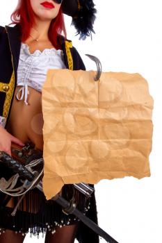 sexy girl in a pirate costume and a cocked hat stands on a white background holding a piece of old parchment worn on a hook with an empty place for text or card.