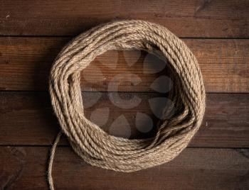 round frame from a skein of coarse rope with place for text on a dark wooden background