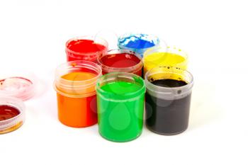 Several open jars of gouache paint of different colors isolated on a white background