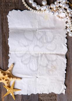 vintage torn blank parchment scroll and starfish and pearls on it