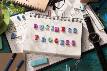 business process concept - inscription and office supplies on the desk 