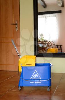 Blue cleaning cart with warning notice.