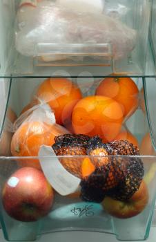 Refrigerator drawer full of oranges and apples.