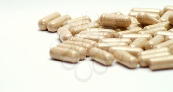 Closeup image of brown pills - roughage on the white background.