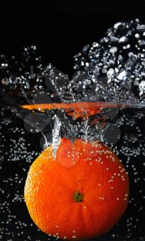 Mandarin falling down to the cold water and making splash.