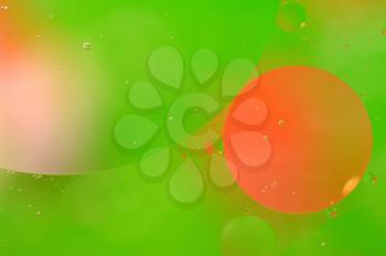 Abstract green background from floating oil bubbles in the water.