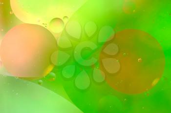Abstract green background from floating oil bubbles in the water.