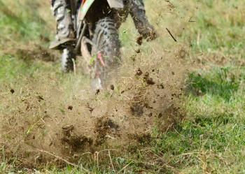 Flying mud from moving motorcycles enduro wheel.
