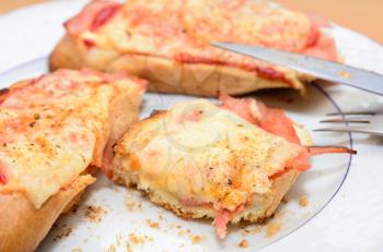 Remains of the ham and cheese baked toast on the plate.