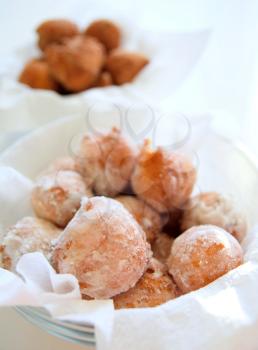 Fresh fried donuts powdered by a sugar in the glasses bowl.