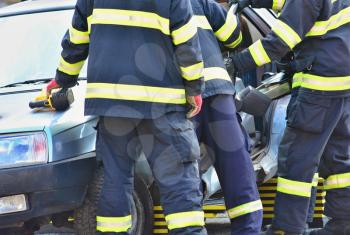 Firefighters and doctors helping the driver after car accident.