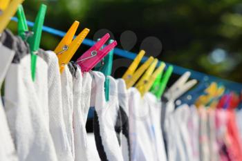 Drying clothes hanged on the clothesline securing with color clothespins.