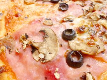 Closeup view of surface pizza Capricciosa with ingredients. Ham, mozzarella, champignons and olives.