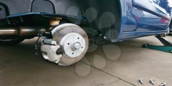 Close-up of a car disc brake with caliper during tyre replacement. Car maintenance.