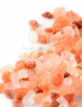 Macro of Pink Himalayan Rock Coarse Salt on White Background.