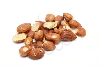 Heap of peeled scattered hazelnuts over white background.