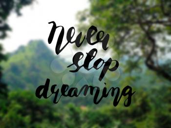 Hand lettering - Never stop dreaming. Motivational poster, print, illustration on nature blur background