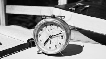 Vintage still life with old alarm clock, keys and books on a white wooden table in Black and White photography