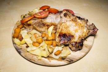 Pork meat with yellow beans ,carrots and tomatoes on a wooden board