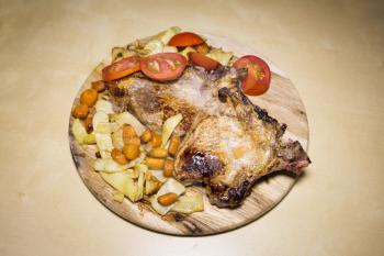 Pork meat with yellow beans ,carrots and tomatoes on a wooden board