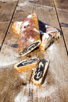 Strudel with poppy seeds on a Wooden Table All Sprinkeld With Shugar Powder