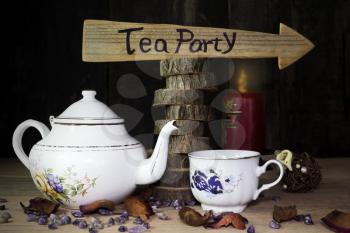 Tea Party. Cup of Tea and Teapot On Wooden Table With Arrow Sign in the Background