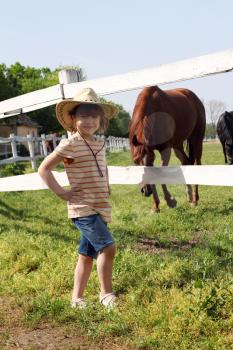 little girl with cowboy hat on ranch