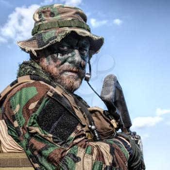 Bearded soldier of special forces on blue sky background