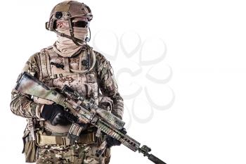 Half length low angle studio shot of special forces soldier in field uniforms with weapons, portrait isolated on white background. Protective goggles glasses are on