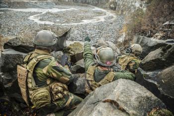 Patrol of norwegian Rapid reaction special forces FSK soldiers in field uniforms in ambush among the rocks guarding perimeter waiting enemy