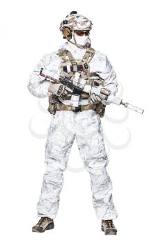 Special forces operator of Navy Seals armed with assault rifle with closed face in polarized sunglasses and military winter camo clothes designed to operations in extreme conditions. Studio shot