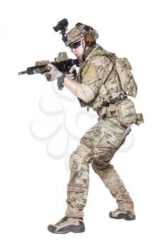 Member of US Army rangers in combat uniforms with his shirt sleeves rolled up, in helmet, eyewear and night vision goggles, ready to firing. Low readiness position. Studio shot, white background