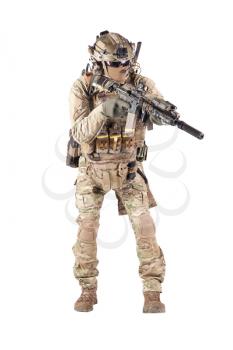Army infantryman in camouflage uniform, battle helmet, tactical radio headset, extra ammo on load carrier, sneaking, aiming with laser sight on assault rifle studio shoot isolated on white background