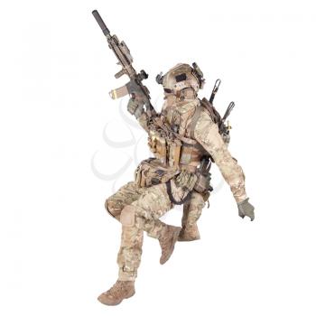Modern army soldier, infantry rifleman equipped with camo battle uniform, tactical helmet with hidden identity behind mask running with assault rifle in hand studio shoot isolated on white background