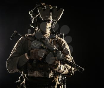 Elite commando fighter, private military company mercenary, special operations serviceman, security or secret service shooter equipped modern weapons and ammunition, studio shoot on black background