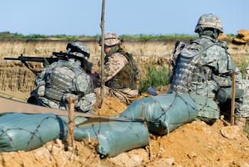 us soldiers with their rifles sitting at the checkpoint