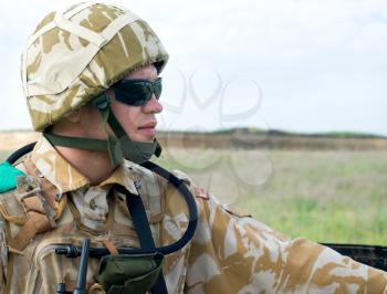 British soldier with the reflection of UK flag in glasses looking forward