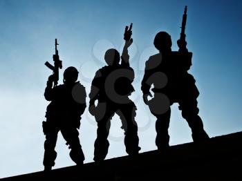 Silhouettes of S.W.A.T. officers holding their guns