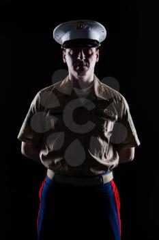 Contour shot of US marine in blue dress uniform on black background