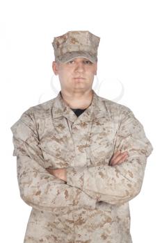 Full length front view studio shoot or army soldier in camouflage uniform and cap, standing in parade rest position with legs on shoulder width and hands behind back isolated on white background