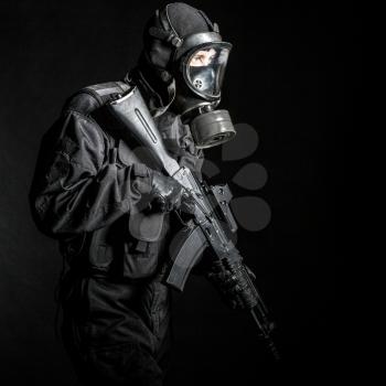 Russian special forces operator in black uniform and gas mask