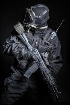 Russian special forces operator in black uniform and gas mask