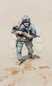 United states airborne infantry man with arms, camo uniforms dress. Combat helmet, knee pads protection wearing, tired and exhausted. moving desert high angle top view